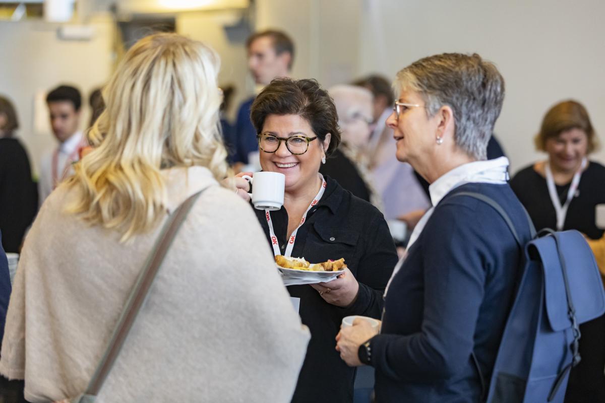 Förtroendevalda personer i OK ekonomisk föreningen samtalar över en kopp kaffe.