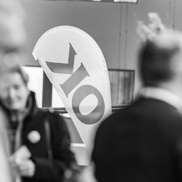 Förtroendevalda i OK ekonomisk föreningen samtalar framför en OK-beachflagga.