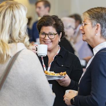 Förtroendevalda personer i OK ekonomisk föreningen samtalar över en kopp kaffe.