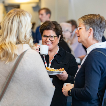 Förtroendevalda personer i OK ekonomisk föreningen samtalar över en kopp kaffe.