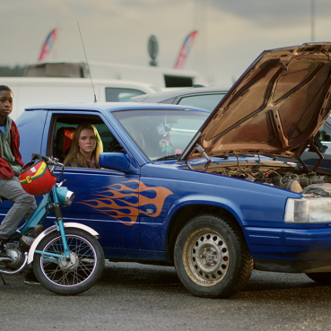 En kille på moped och en tjej i en EPA-traktor. OK-logotype nedre högra hörnet.