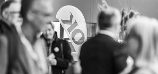 Förtroendevalda i OK ekonomisk föreningen samtalar framför en OK-beachflagga.